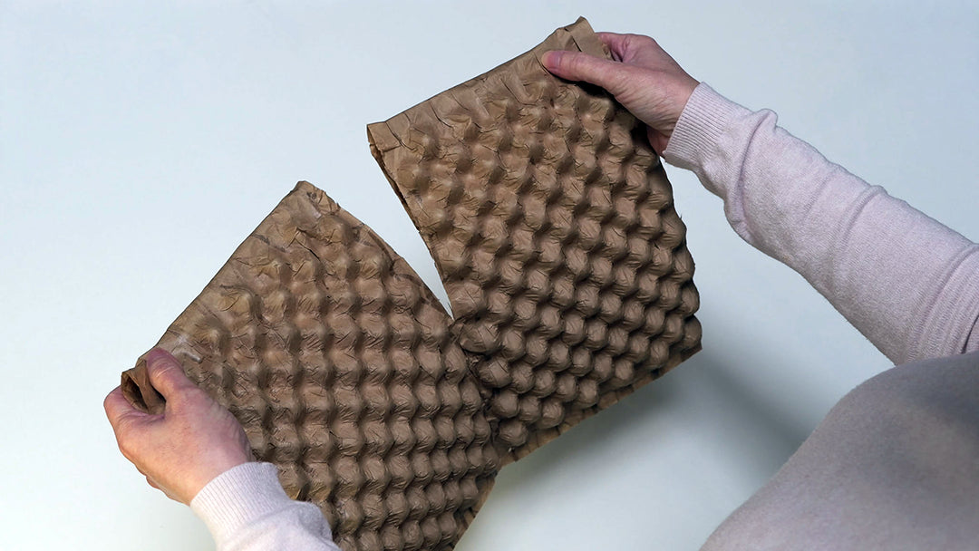 Une personne montrant que le produit Naturbubble, le vrai papier bulle est sécable facilement